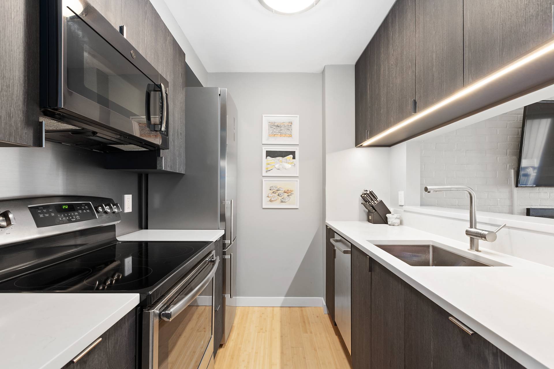 514 Pantigo Road, Unit 7 East Hampton, NY 11937 - Photo 7 of 14 a kitchen with stainless steel appliances granite countertop a sink stove and microwave