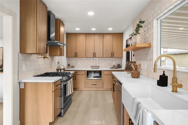 a kitchen with stainless steel appliances granite countertop a sink stove and refrigerator