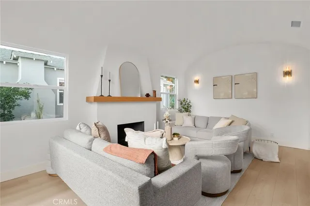 a living room with furniture a large window and a fireplace