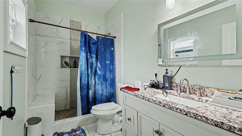 5211 Southwest 103rd Loop Ocala, FL 34476 - Photo 11 of 18 a bathroom with a granite countertop sink toilet and shower