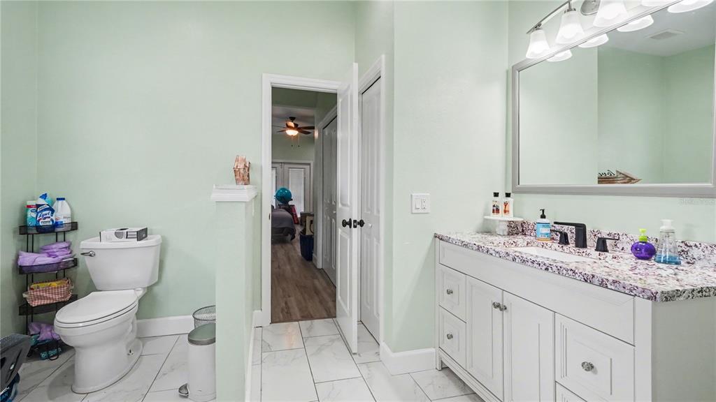 5211 Southwest 103rd Loop Ocala, FL 34476 - Photo 14 of 18 a bathroom with a granite countertop toilet sink and mirror
