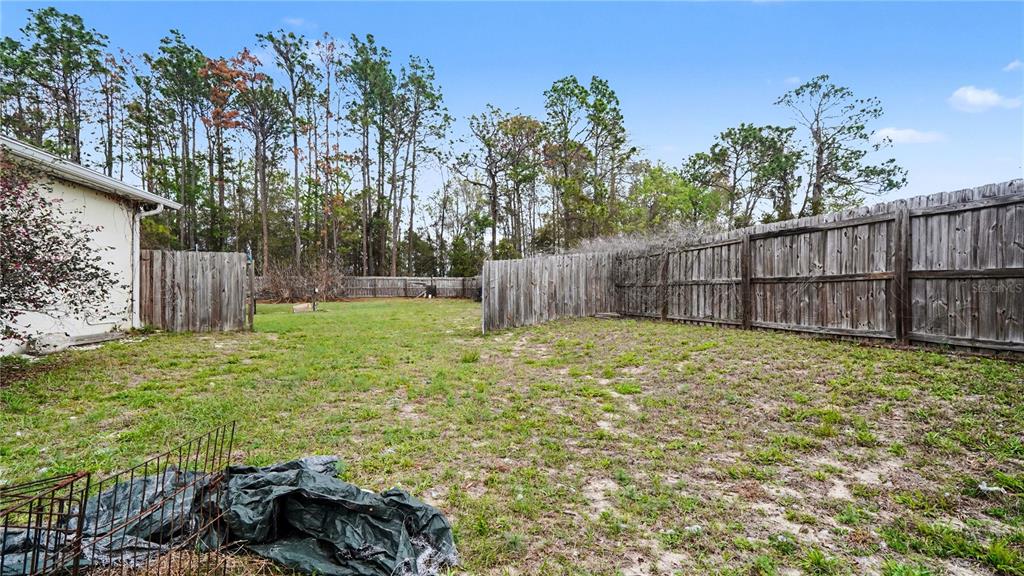 5211 Southwest 103rd Loop Ocala, FL 34476 - Photo 15 of 18 a view of a backyard with wooden fence