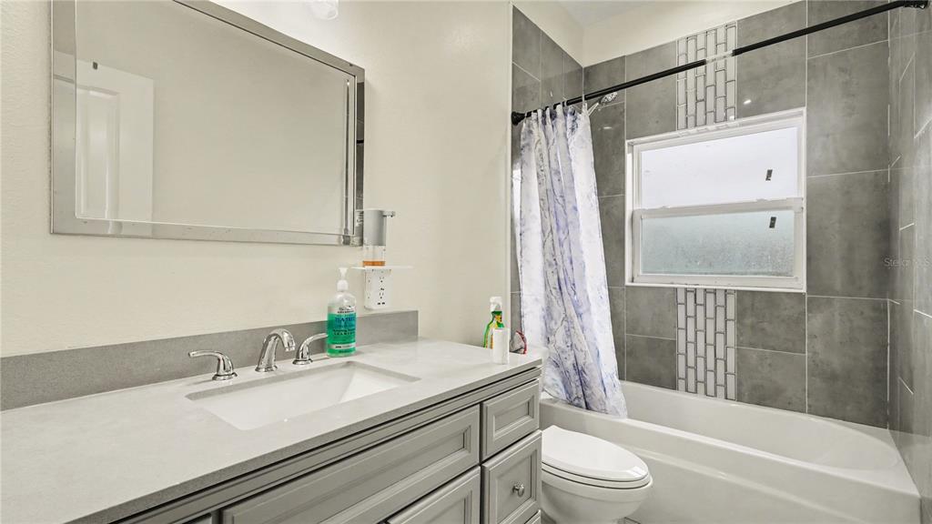 5211 Southwest 103rd Loop Ocala, FL 34476 - Photo 9 of 18 a bathroom with a granite countertop sink toilet and shower