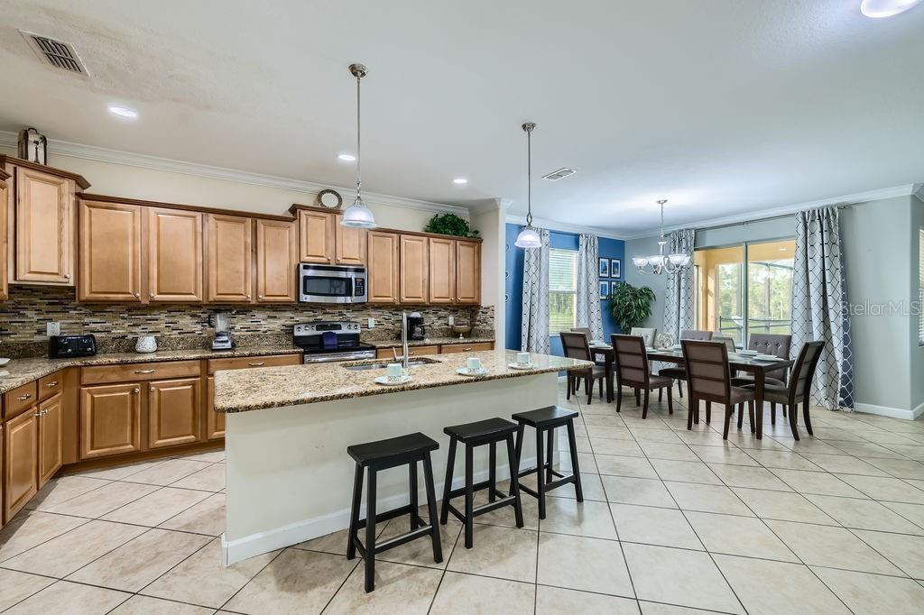 2999 Buccaneer Palm Road Kissimmee, FL 34747 - Photo 12 of 49 a kitchen with microwave a dining table and chairs