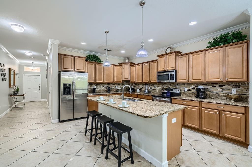 2999 Buccaneer Palm Road Kissimmee, FL 34747 - Photo 13 of 49 a kitchen with stainless steel appliances granite countertop a stove top oven a refrigerator a sink and a island