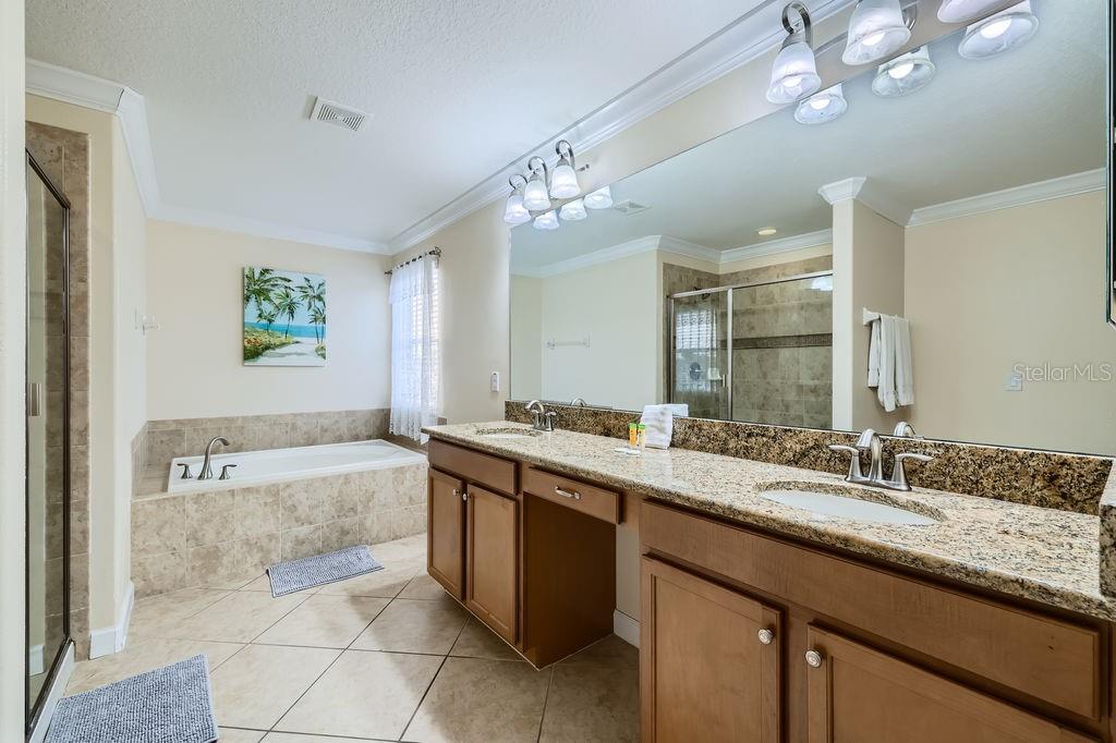 2999 Buccaneer Palm Road Kissimmee, FL 34747 - Photo 19 of 49 a spacious bathroom with a granite countertop sink a large mirror and a bathtub