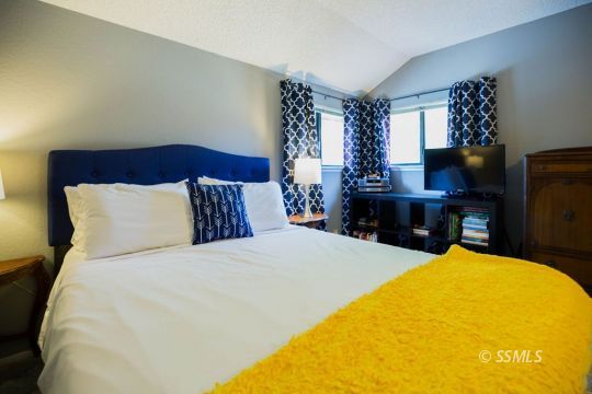 415 Tepatitlan Court Ridgecrest, CA 93555 - Photo 15 of 33 a bed sitting in a bedroom next to a window with a chandelier