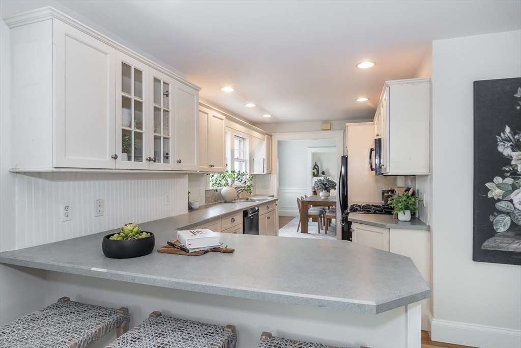 11 Durant Road Wellesley, MA 02482 - Photo 10 of 28 a kitchen with stainless steel appliances granite countertop a sink a stove white cabinets and wooden floor