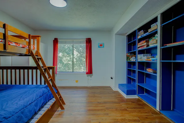 a bedroom with a bed and wooden floor