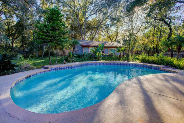 a living room with furniture a flat screen tv and floor to ceiling window