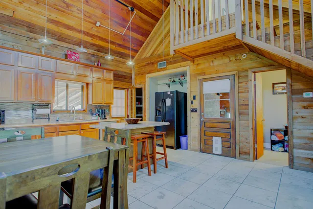 a dining hall with stainless steel appliances granite countertop a sink and cabinets