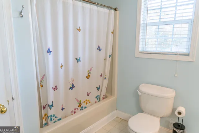 a white toilet sitting next to a shower curtain