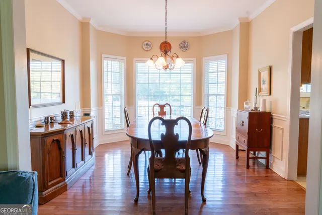 a view of a a dining room with furniture window and wooden floor