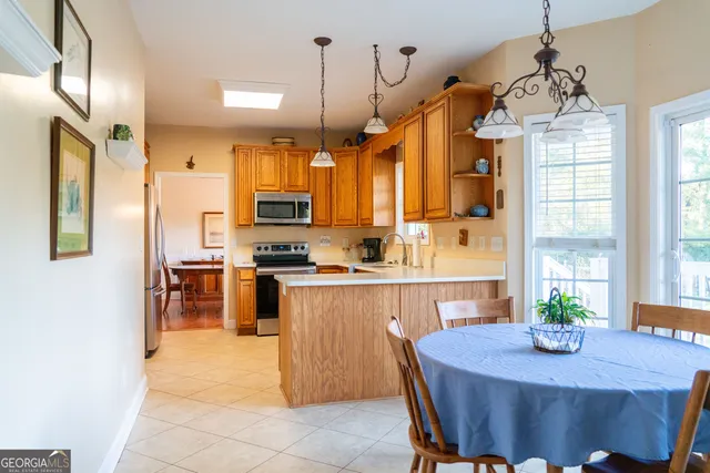 a kitchen with sink refrigerator dining table and chairs