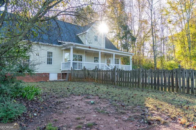 a view of a house with a yard and large trees