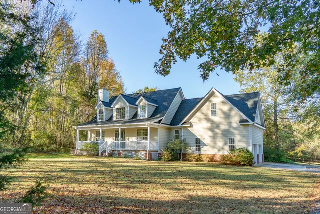 a view of a big house with a big yard and large trees