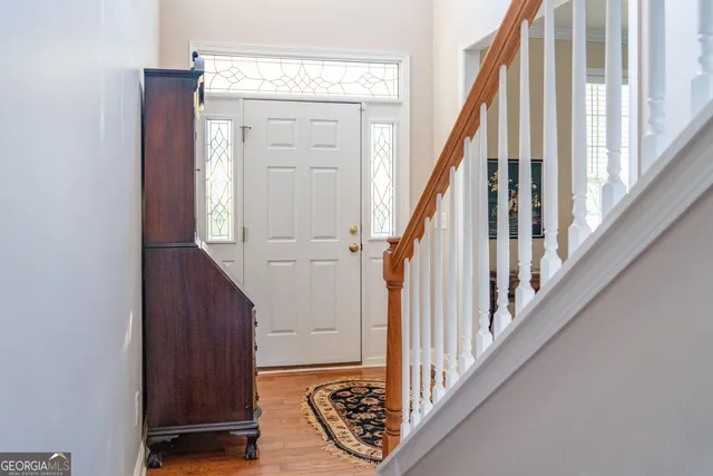 a view of staircase with wooden floor and white walls