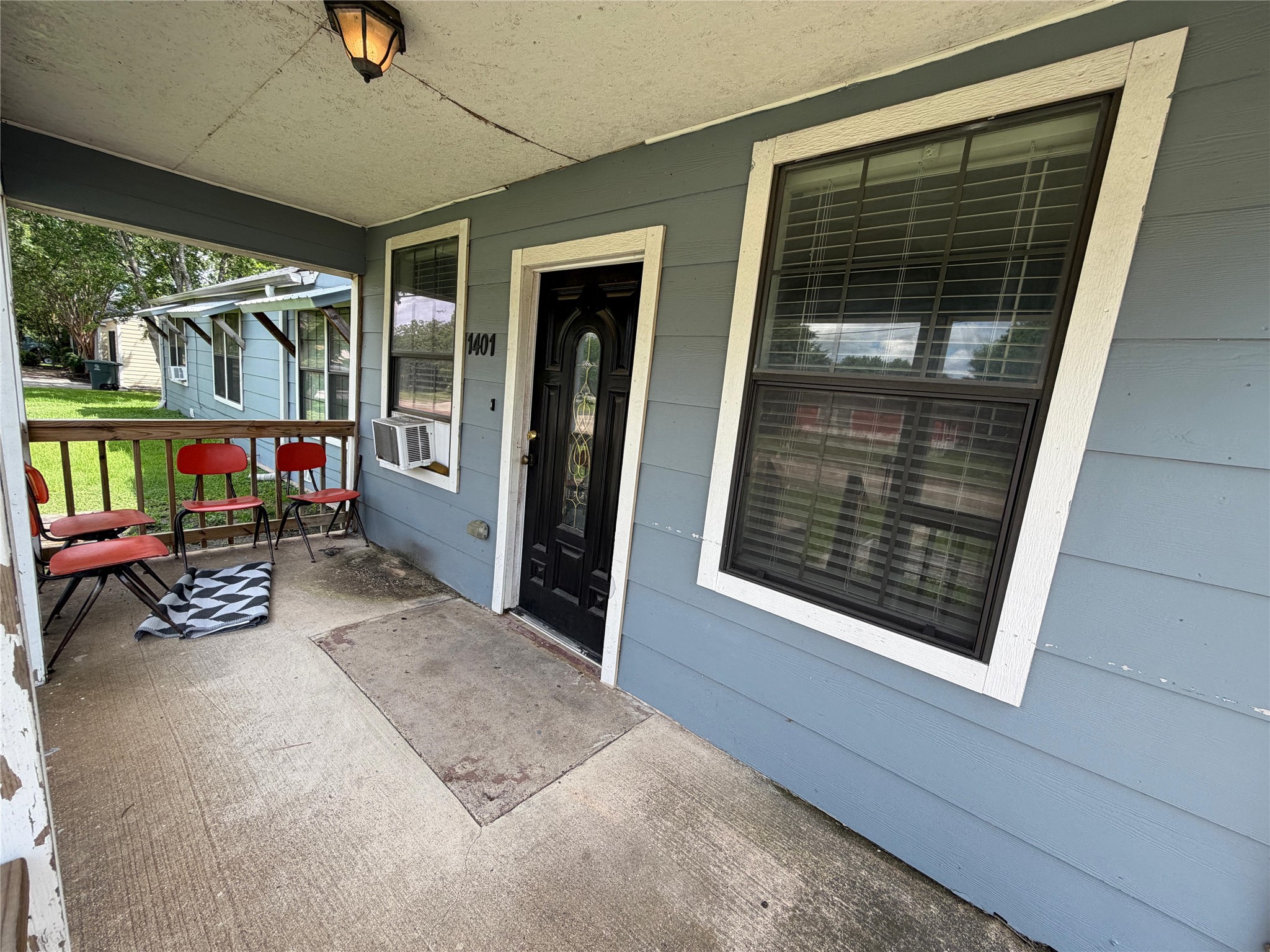 1401 East 29th Street Bryan, TX 77802 - Photo 9 of 13 A welcoming front porch features a classic black entry door and a clear house number.