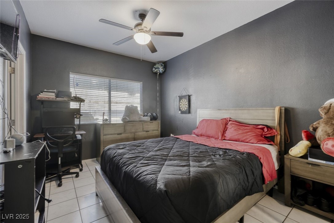 8725 West Flamingo Road, Unit 134 Las Vegas, NV 89147 - Photo 16 of 24 Bedroom featuring light tile patterned floors, ceiling fan, and a desk