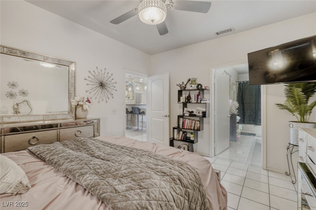 8725 West Flamingo Road, Unit 134 Las Vegas, NV 89147 - Photo 4 of 24 Bedroom with light tile patterned flooring, a ceiling fan, and ensuite bathroom