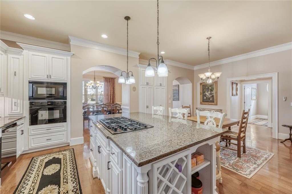 2380 Muskogee Lane Braselton, GA 30517 - Photo 12 of 30 a kitchen with stainless steel appliances granite countertop a stove a sink dishwasher and white cabinets with wooden floor