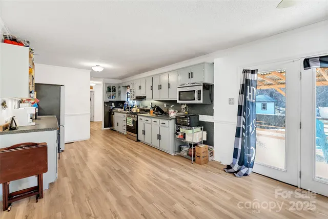 a view of kitchen with cabinets stainless steel appliances and wooden floor