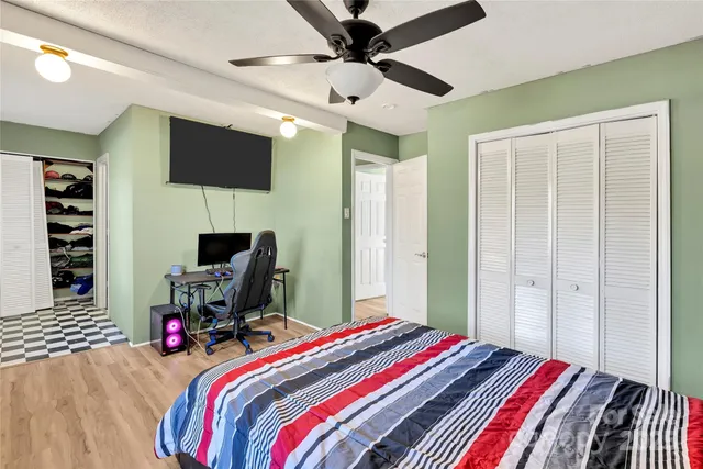 a bedroom with a bed a flat screen tv and a chandelier