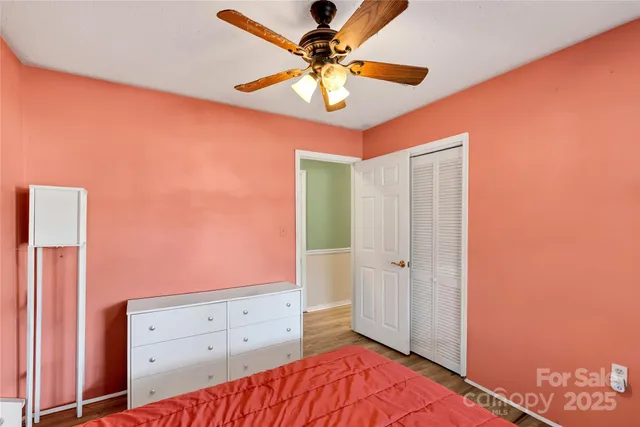 a bedroom with a bed and a chandelier fan