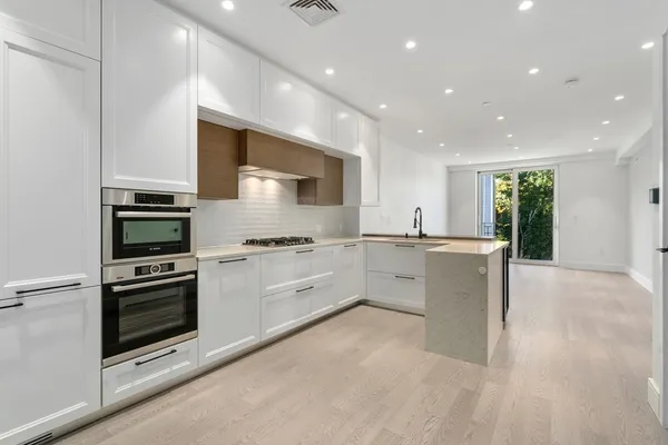 a kitchen with stainless steel appliances granite countertop a stove a sink and a refrigerator