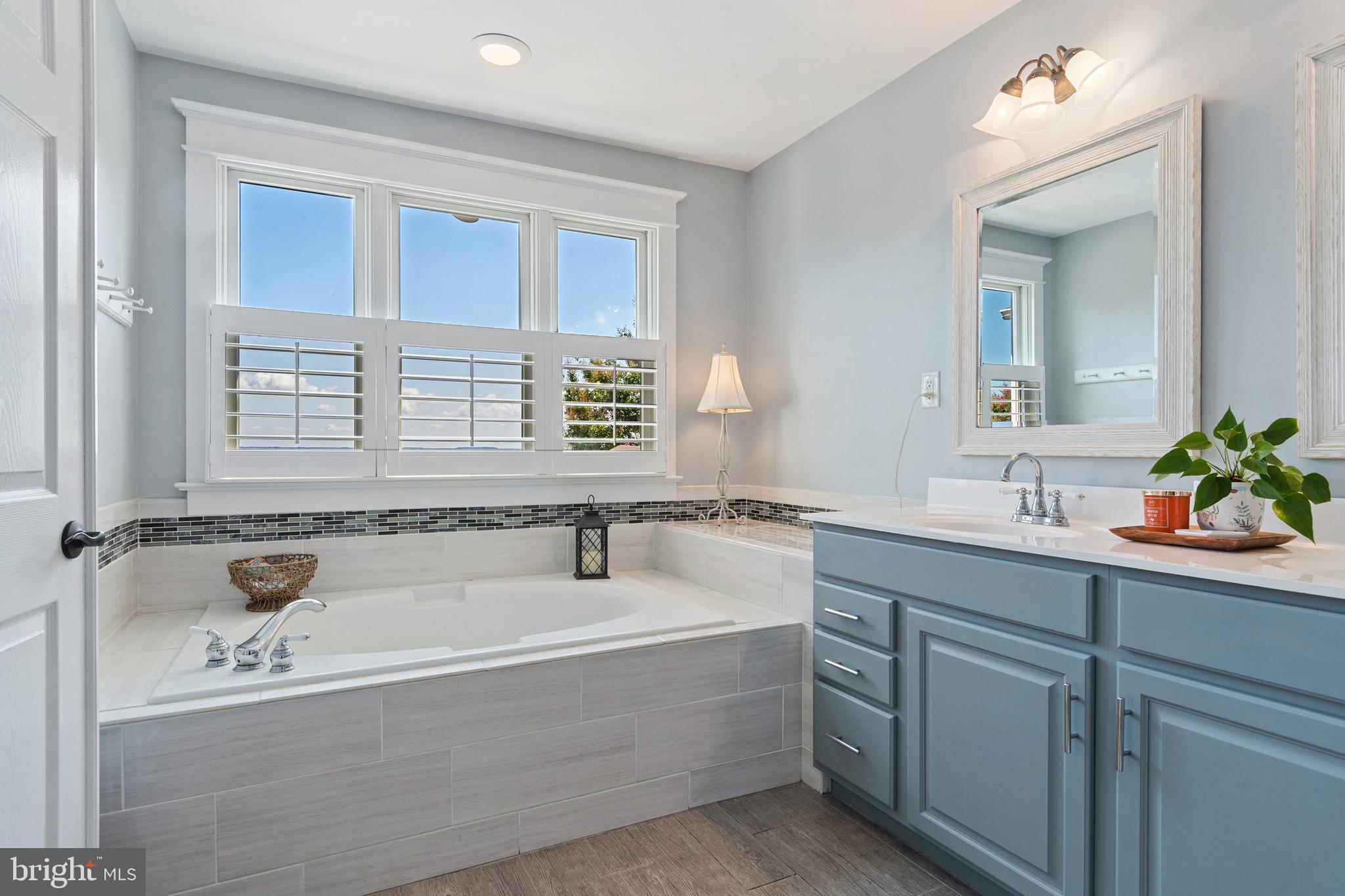2861 Cox Neck Road Chester, MD 21619 - Photo 42 of 79 a bathroom with a tub a sink and mirror