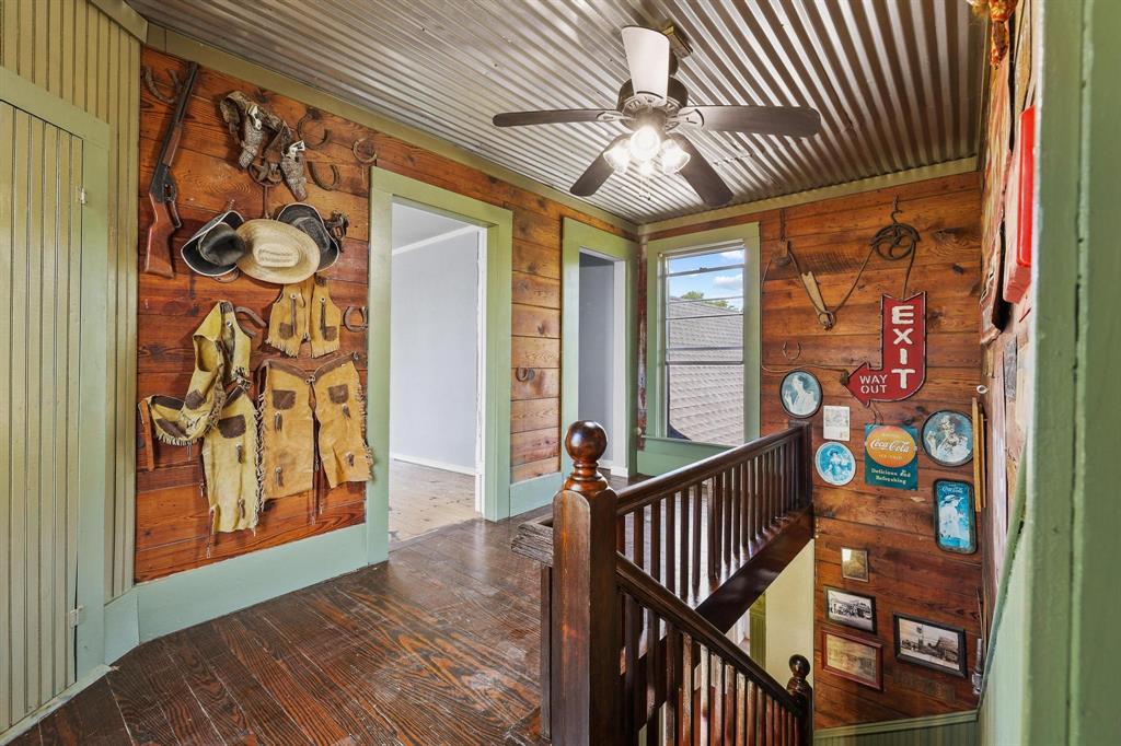 4453 Farm To Market 902 Howe, TX 75459 - Photo 36 of 40 Upstairs landing are with wood-paneled hallway featuring dark wood-finish flooring, a corrugated metal ceiling, and a dark wood banister