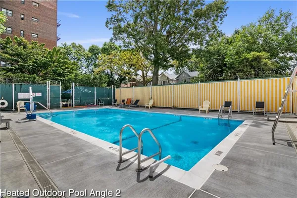 a view of a swimming pool with a patio and a yard