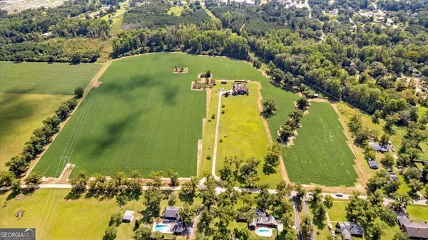 an aerial view of a residential houses with outdoor space and swimming pool