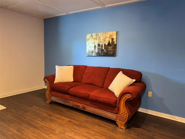a blue couch sitting in a living room with wooden floor