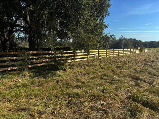 a view of a yard with wooden fence