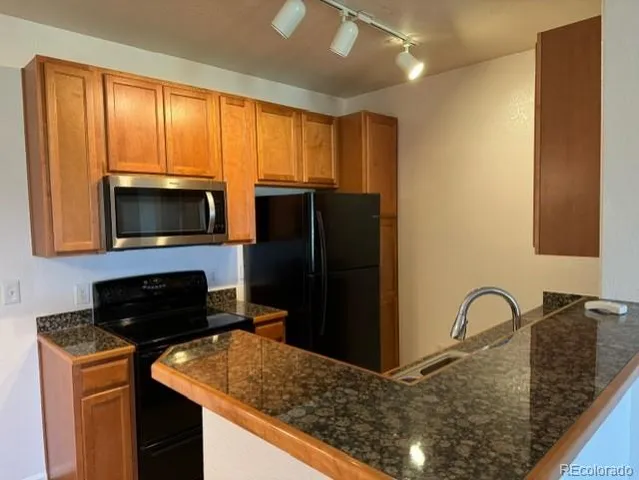 a kitchen with a refrigerator and a stove top oven