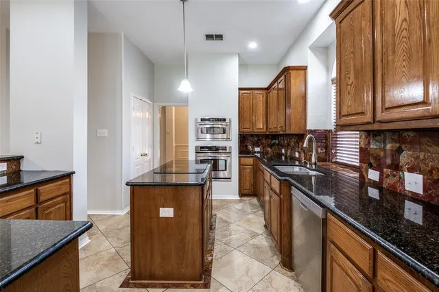 a kitchen with stainless steel appliances granite countertop a stove a sink and a microwave