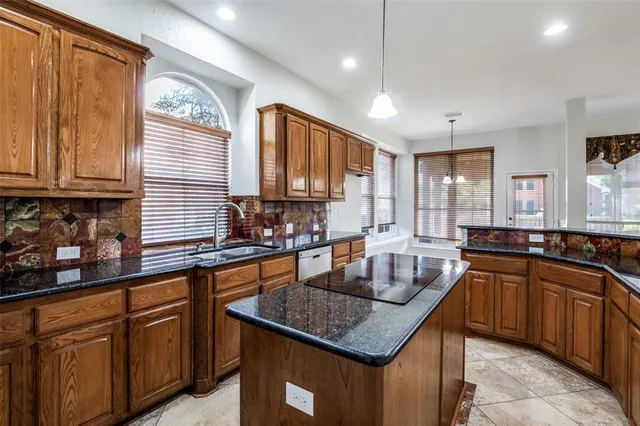 a kitchen with stainless steel appliances granite countertop a sink a counter space and a window