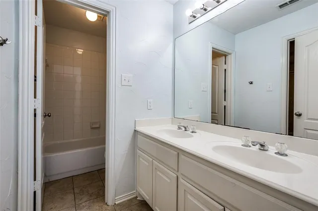a bathroom with a double vanity sink and a mirror