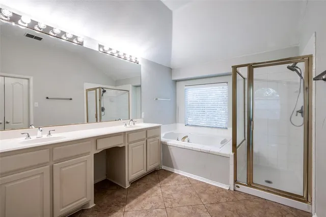a spacious bathroom with a double vanity sink mirror and bathtub