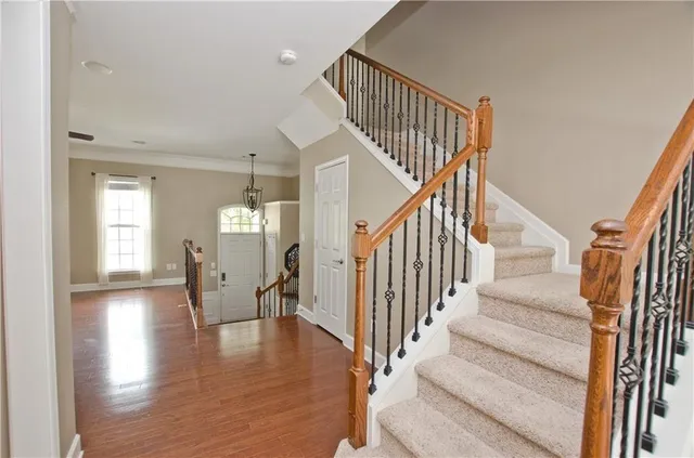 a kitchen with stainless steel appliances granite countertop a stove a sink dishwasher a refrigerator and a dining table with wooden floor