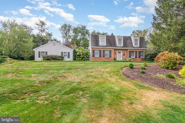 a view of a house with a big yard and large trees