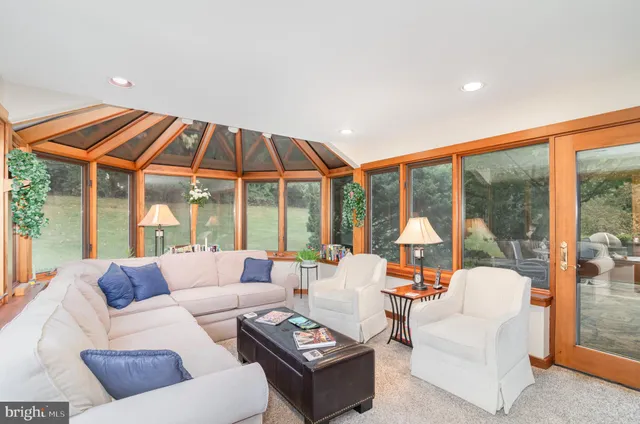 a living room with furniture a large window and a chandelier