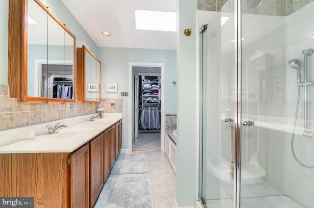 a bathroom with a double vanity sink mirror and shower