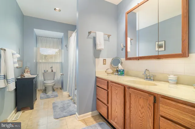 a spacious bathroom with a granite countertop sink and a mirror