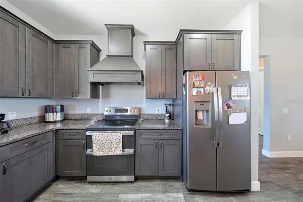 a kitchen with stainless steel appliances granite countertop a refrigerator and a stove