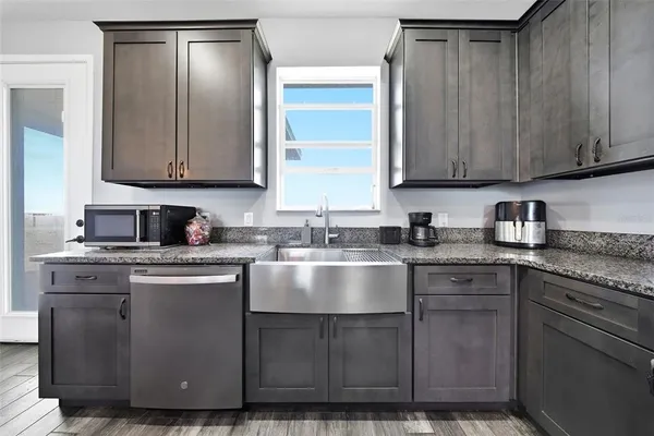 a kitchen with cabinets a sink and stainless steel appliances
