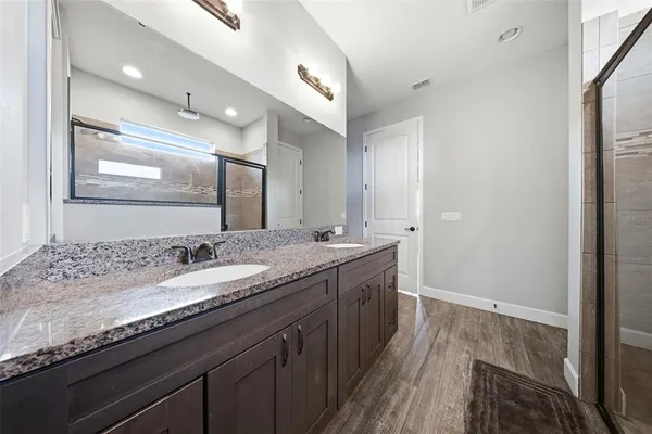 a bathroom with a granite countertop sink a large mirror and vanity