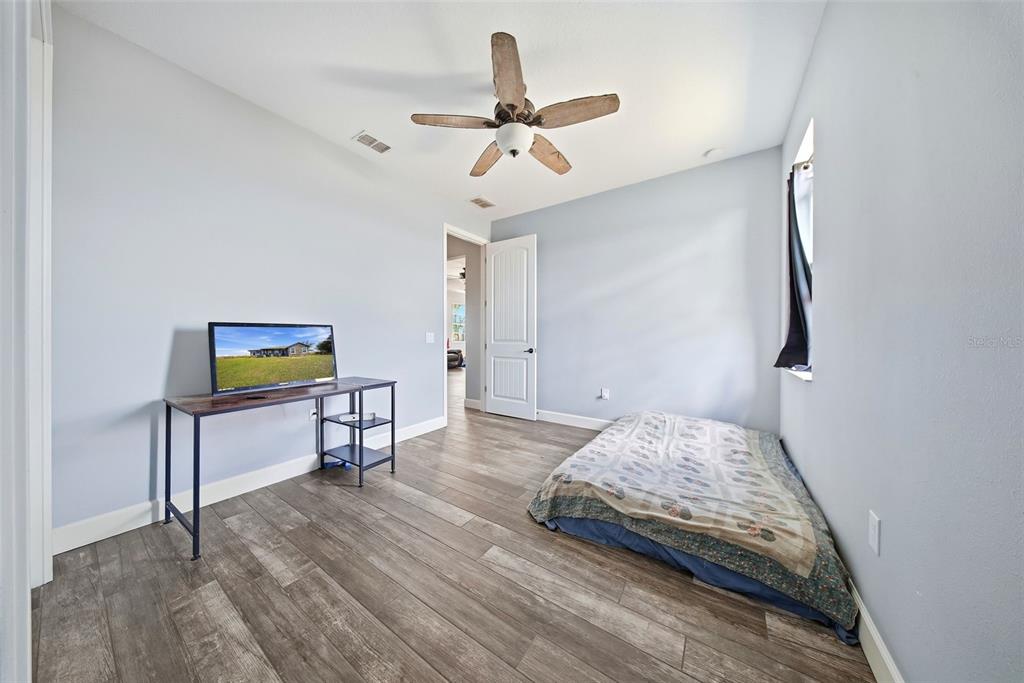 3090 80 Foot Road Bartow, FL 33830 - Photo 25 of 48 a bedroom with a bed and a chandelier