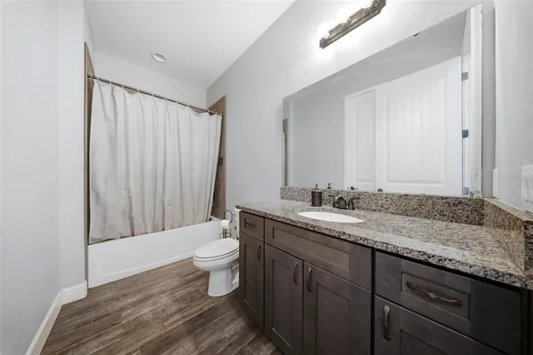 a bedroom with furniture and a wooden floor